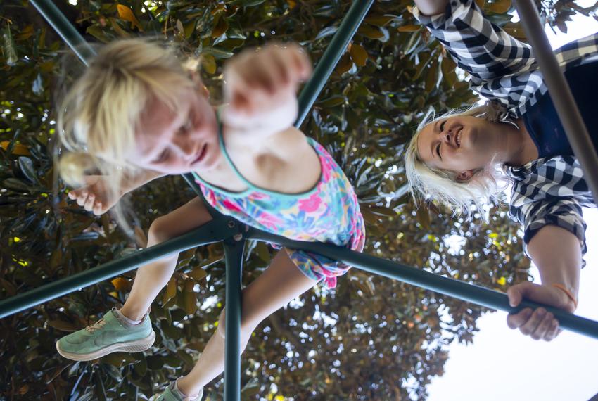 Eight-year-old Sunny Bryant climbs on a dome at her Waldorf-inspired school as her mother Rebekah looks on, in Houston on Sept. 23, 2021.